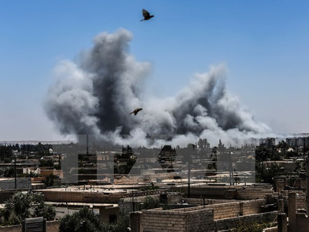 Khói bốc lên sau một cuộc không kích ở Raqqa, Syria ngày 15/7.